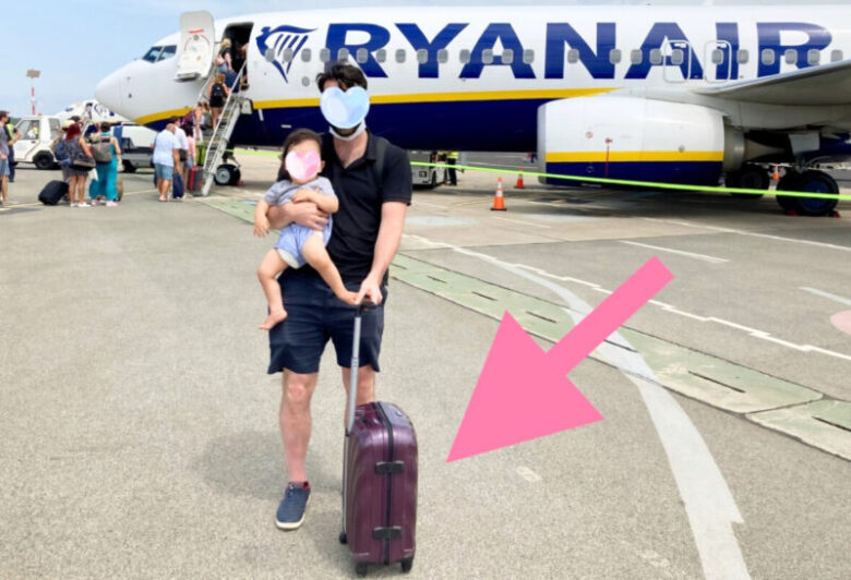 飛行機に乗り込む前、サムソナイトのスーツケースを持った夫と息子