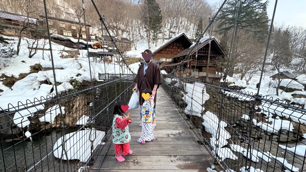 群馬県の宝川温泉にある大露天風呂へ向かう橋を渡る家族