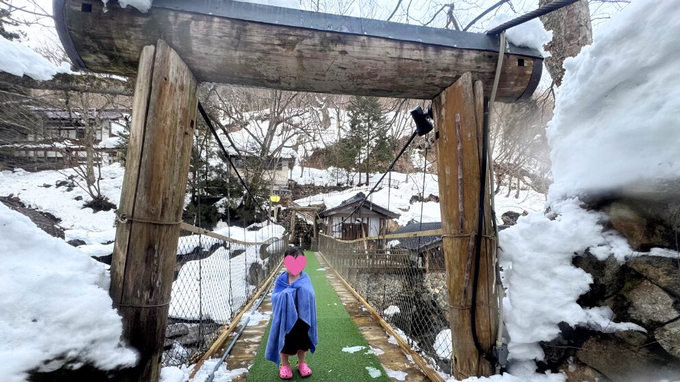 群馬県の宝川温泉にある大露天風呂「子宝の湯」へ向かう橋にいる娘